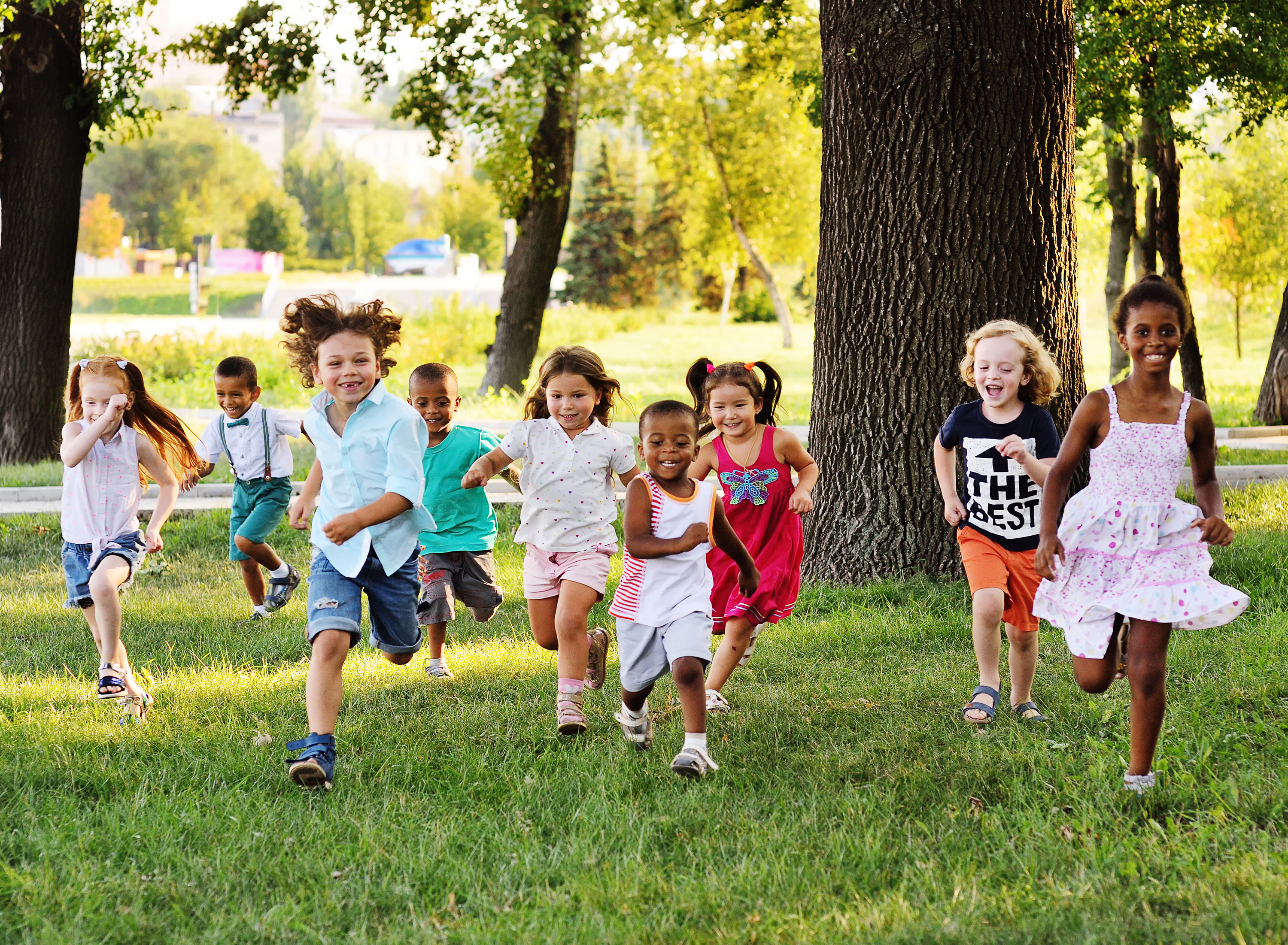 Das Bild zeigt eine über einen Rasen rennende Kindergruppe – 