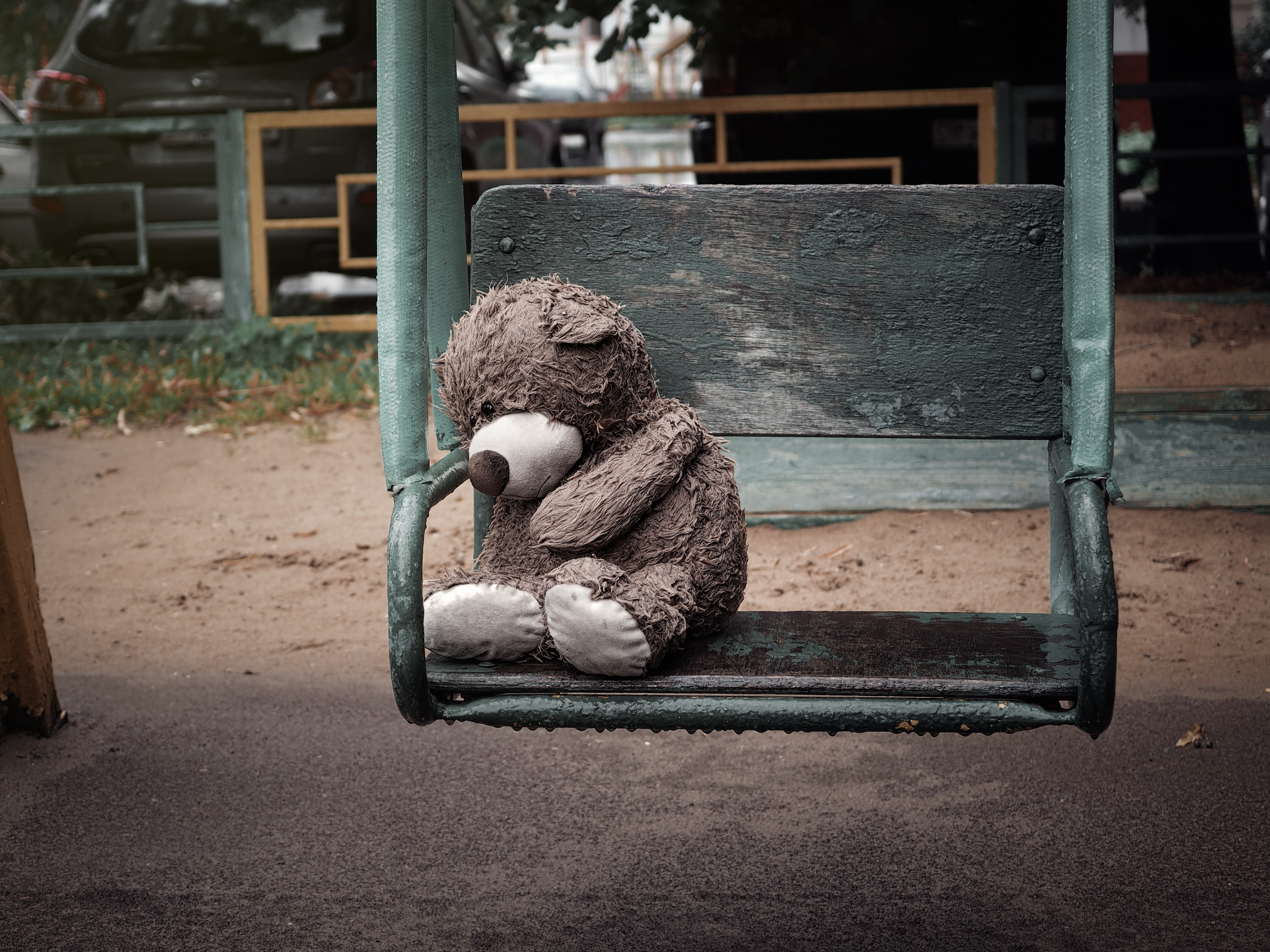 Das Bild zeigt einen auf einer Schaukel sitzenden Teddybären – 